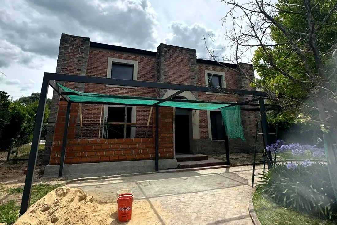 Durante la obra — pérgola metálica y nueva mampostería del frente