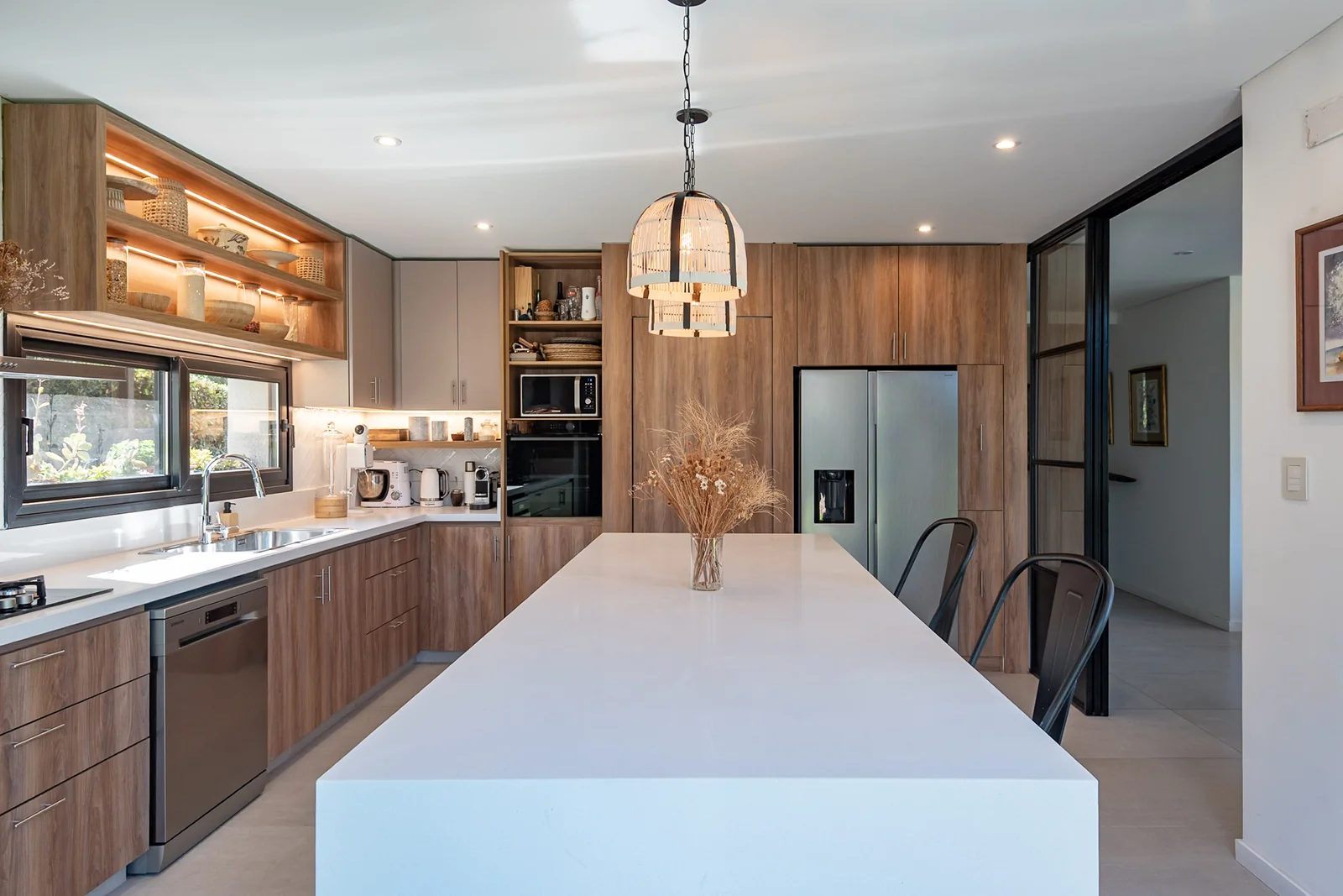 Cocina con isla de cuarzo y muebles de madera